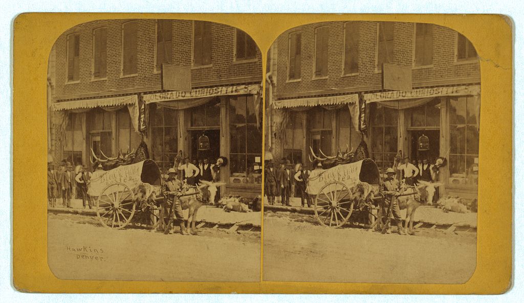 Stereograph of Denver's 16th Street around 1875, with shops, a wagon, and pedestrians