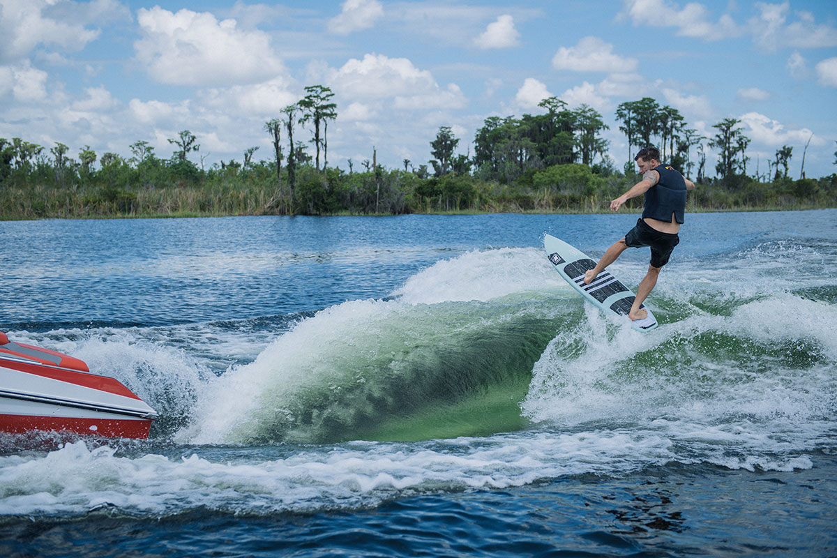 A rider wakesurfing behind a purpose-built surf boat